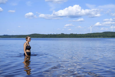 Man standing in water against sky