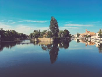 Reflection of trees in lake against blue sky