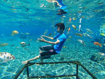 A young man who dives with fish in a place called umbul ponggok in central java, indonesia