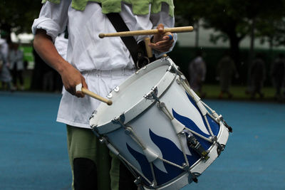 Midsection of musician playing drum