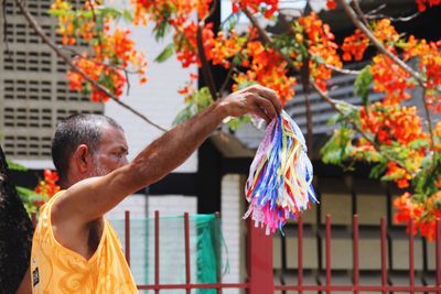 Low angle view of woman holding multi colored flowers