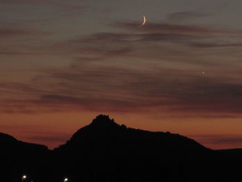 Silhouette of mountain against cloudy sky