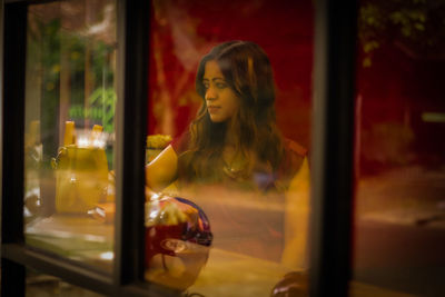 Woman looking through glass window