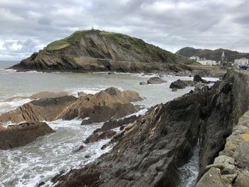 Scenic view of rocky beach against sky