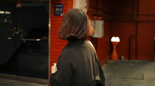 Rear view of a woman standing in the dark