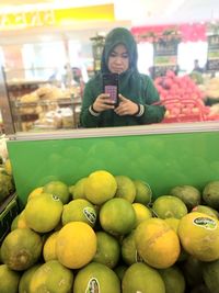 Full length of a young woman holding food at market stall