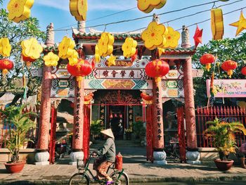 Side view of woman riding bicycle by temple