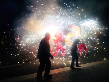 People watching firework display at night