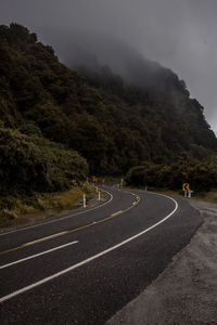 Road by mountain against sky