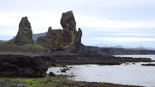 Scenic view of rock formation by sea against sky