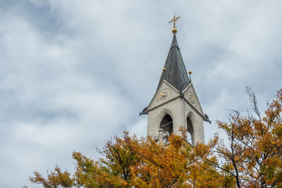 Low angle view of trees and building against sky