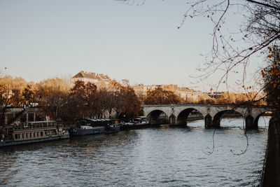 Arch bridge over river against clear sky