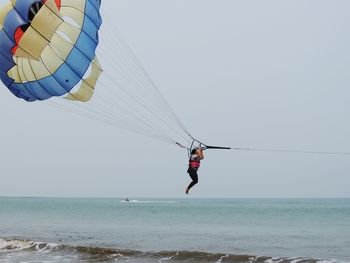 Woman parasailing over sea
