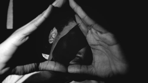 Midsection of person holding hands against black background