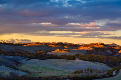 Aerial view of landscape against cloudy sky during sunset