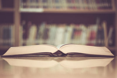 Close-up of open book on table in library