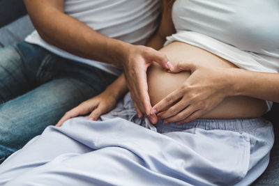 Midsection of man touching woman