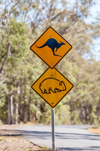 Road sign against trees