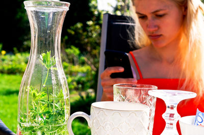 Close-up of woman holding drink in glass on table