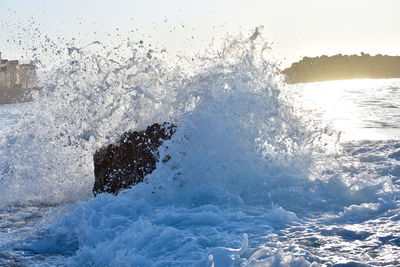 Water splashing in sea against sky