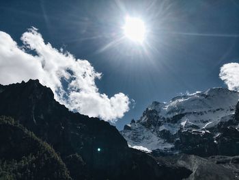 Low angle view of snowcapped mountains against sky on sunny day