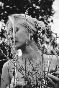 Close-up of woman by flowering plant