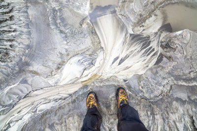 Low section of man standing on glacier