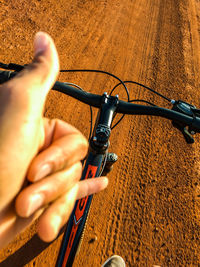 Midsection of man riding bicycle on road