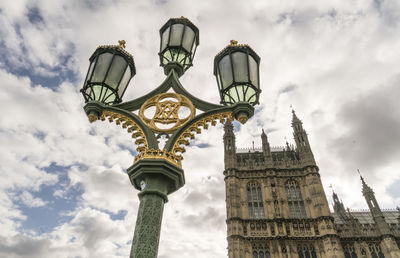 Low angle view of street light against cloudy sky