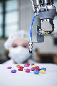 Robot handling sweets with woman in background