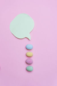 Close-up of multi colored candies against pink background