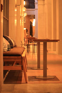Empty chairs and tables in illuminated building