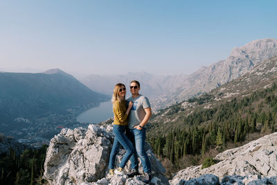 Side view of woman standing against mountain