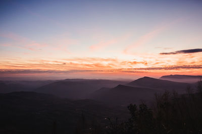 Scenic view of silhouette mountains against sky during sunset