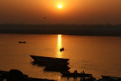 Silhouette boat in sea against sky during sunset