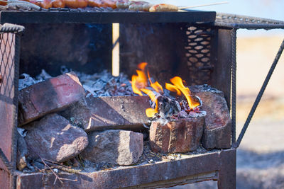 Fire in a rusty vintage grill outdoor with blurred background.