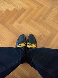 Low section of person relaxing on hardwood floor