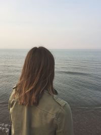 Rear view of woman overlooking calm sea