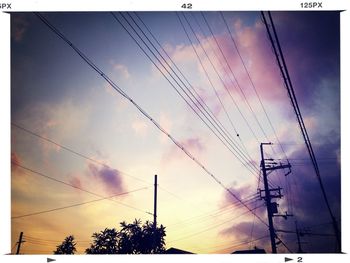 Low angle view of electricity pylon against cloudy sky