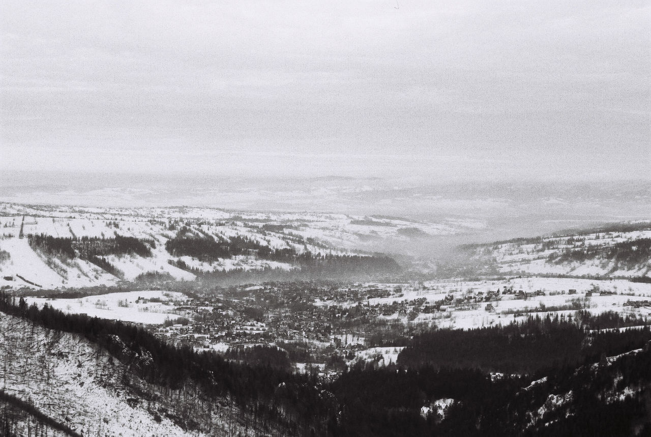 environment, scenics - nature, landscape, snow, beauty in nature, sky, nature, cold temperature, winter, black and white, land, mountain, tranquility, monochrome photography, tranquil scene, no people, monochrome, day, cloud, plant, non-urban scene, outdoors, high angle view, mountain range, tree, travel, travel destinations, remote, tourism, idyllic