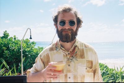 Portrait of man drinking cocktail in domestic garden 