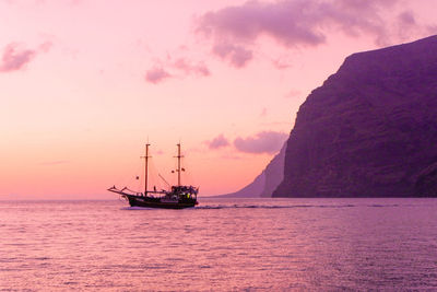 Sailboat sailing on sea against sky during sunset