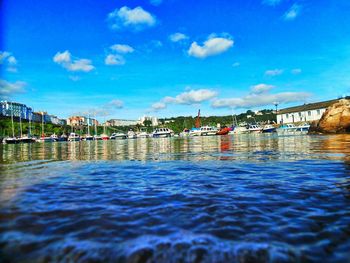 Boats in sea with buildings in background