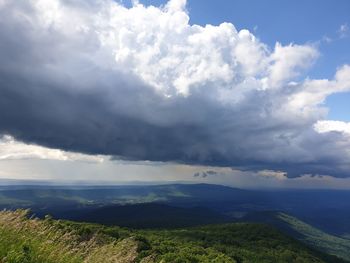Scenic aerial view of field against  sky covered with cotton cloud.
