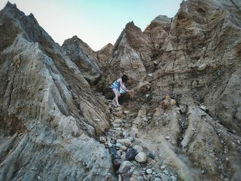 Woman walking on rocky mountains