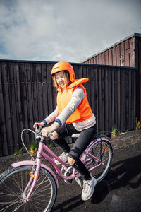 Smiling girl riding bicycle on road