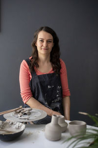 Portrait of a smiling young woman sitting on table