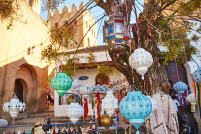 Low angle view of decorations hanging by tree against building