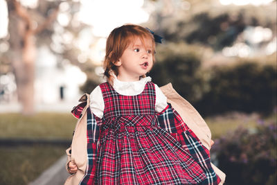 Cute girl looking away while standing at park