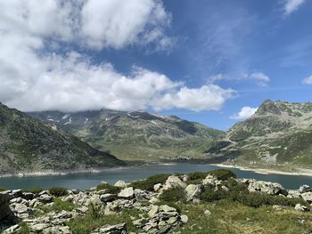 Scenic view of lake by mountains against sky